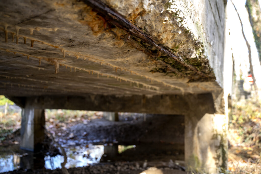 The underneath of a stone bridge. Some rust is visible.